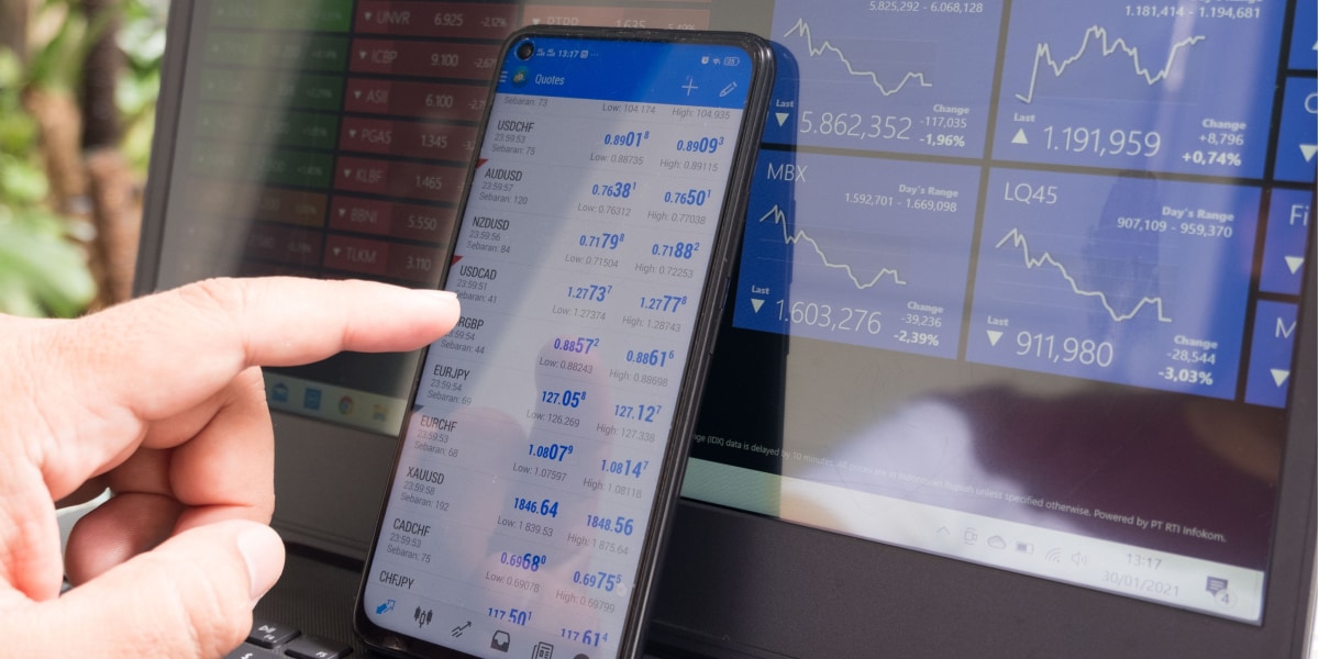 A man analysing stock market data on his MT4 account through his phone.