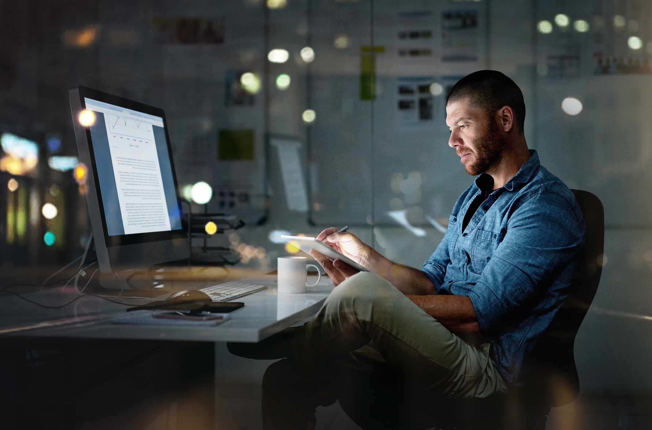 Man investing at desk at night
